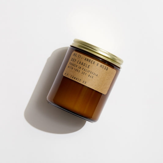 No. 11 Amber & Moss Soy candle in amber jar with craft label and brass lid.