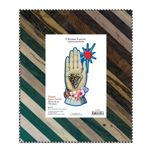 Christian Lacroix puzzle, whimsical illustrated art depicting a hand palm, heart, floral, and heart. Back of box