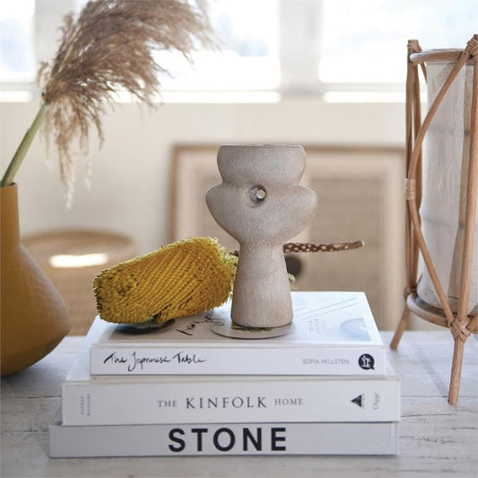 sculptural vase in natural sand color. Small hole in center on top of books and other decor items