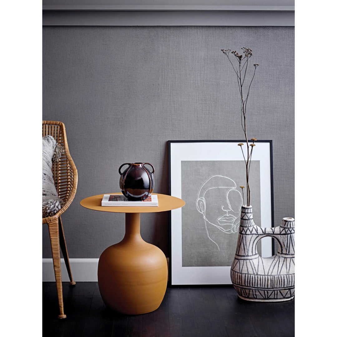 Modern collage of home decor products with a focus on abstract vase, black and white striped pattern, painted by hand, with long dried floral stem.