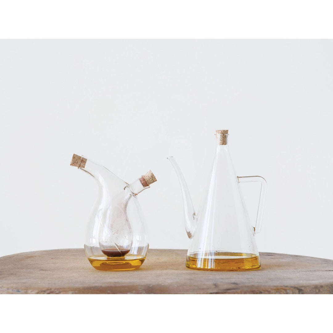 Clear glass oil and vinegar cruet sets on wooden table
