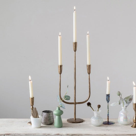 Collection of candelabra and candle holders with vases