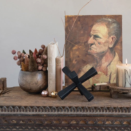 Collection of  home decor items - bowl with dried flowers, books, wooden jack, lit candle with canvas print of old man. 
