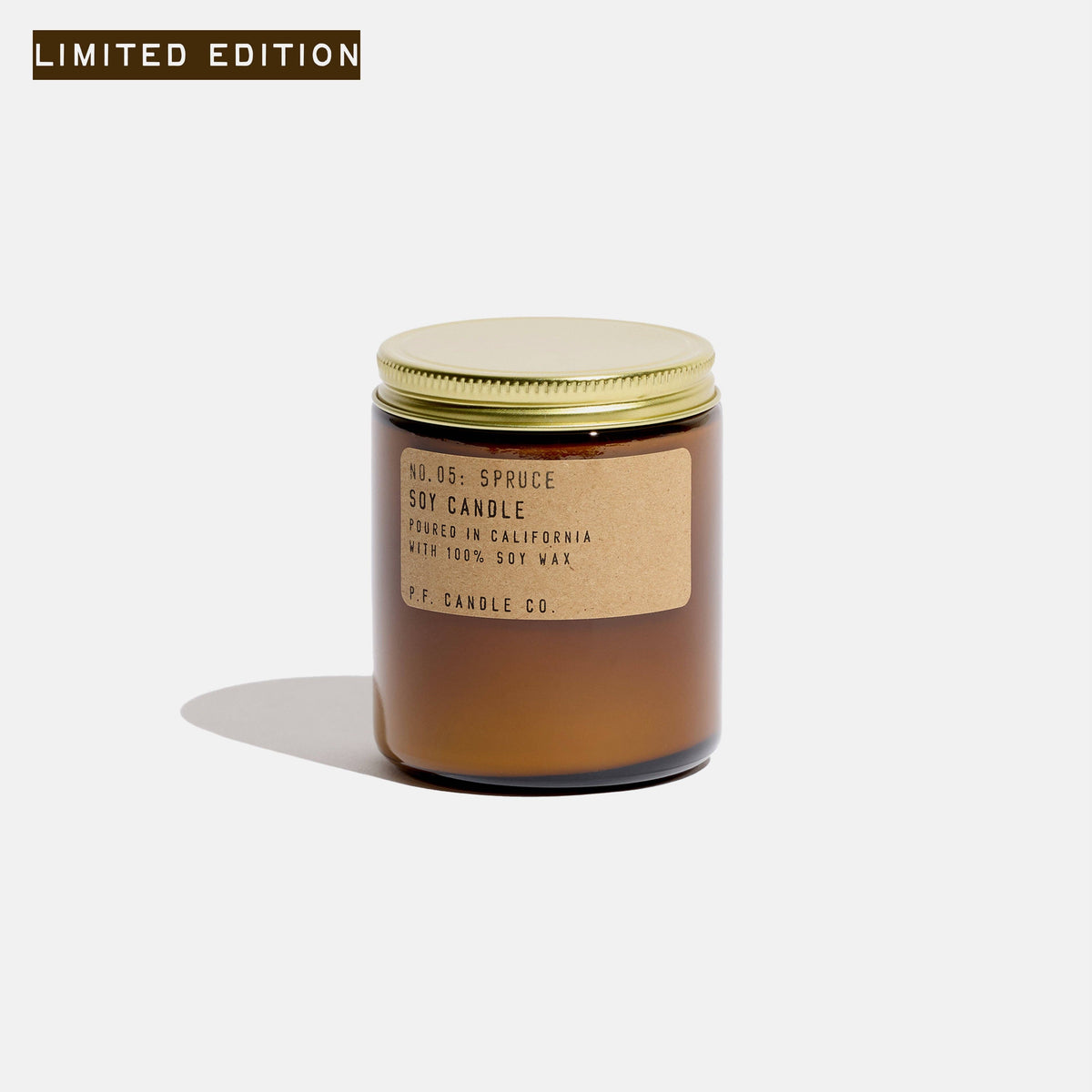 Spruce soy candle in an amber glass jar with gold lid and kraft label, marked limited edition