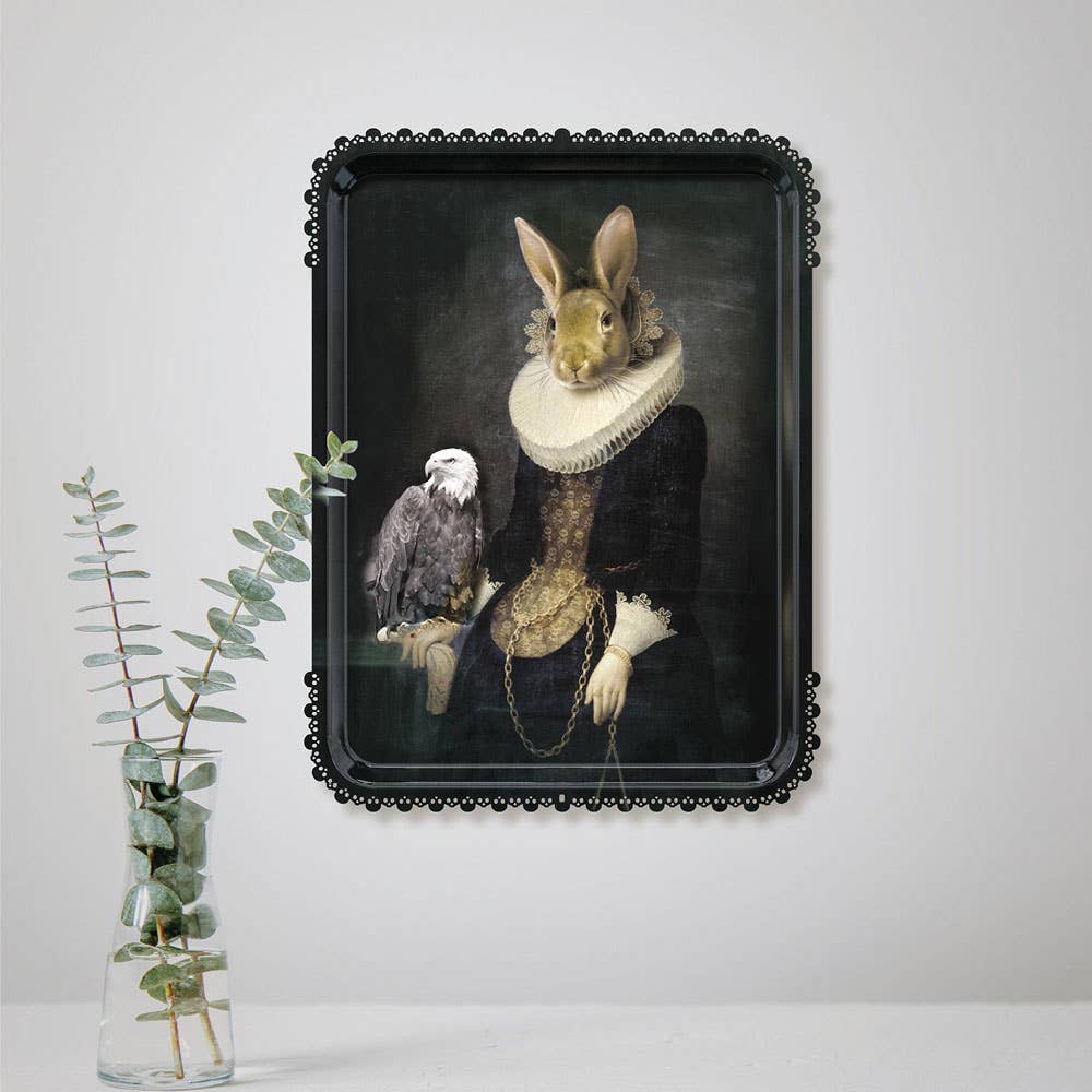 Zhao tray with scalloped black rim displayed on a wall above a glass vase of eucalyptus stems