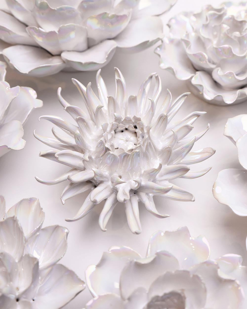 Pearlescent medium flower among other white ceramic flowers, showing its soft shimmer