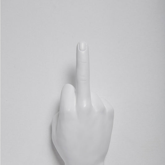 White middle finger hand wall hook mounted on a light gray wall, cropped close