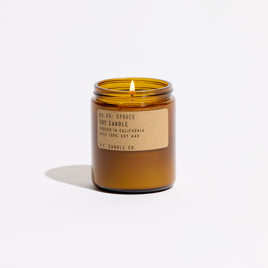 Amber glass candle with a label on a white background