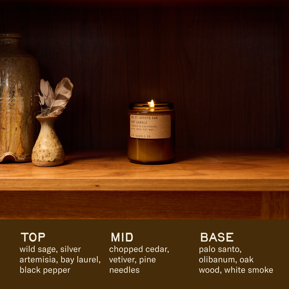 Lit Arroyo Oak candle on a wood shelf with scent notes: wild sage, cedar, vetiver, palo santo, oak wood