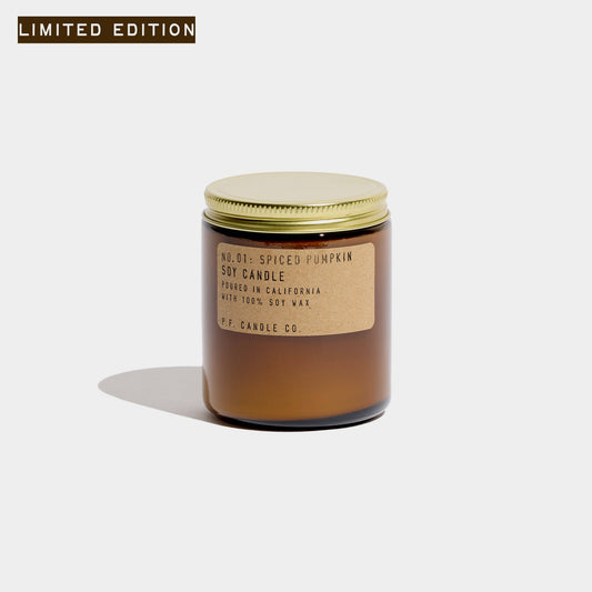 Spiced Pumpkin soy candle in an amber glass jar with gold lid and kraft label, limited edition tag