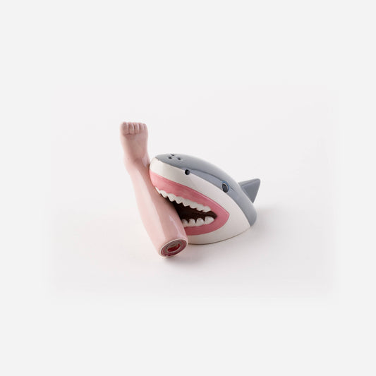 Shark salt shaker biting a foot-shaped pepper shaker, gray and white shark with pink leg