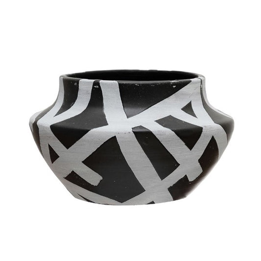 Round terracotta pot in black with white abstract designs.