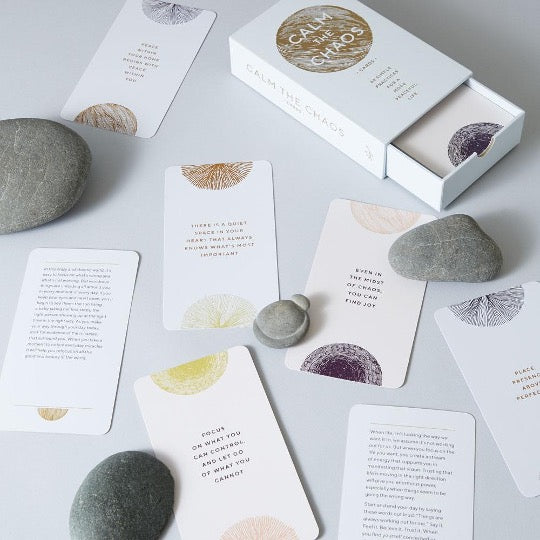 Assorted cards on tables with river rocks