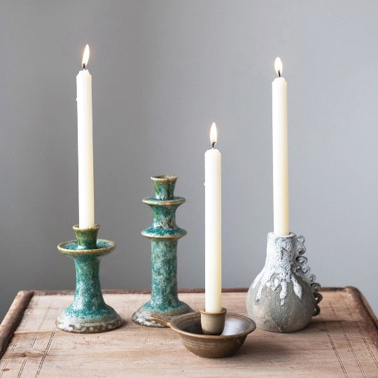 collection of candle holders with lit candles on wooden table
