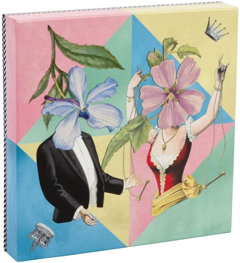 Christian Lacroix puzzle, whimsical illustrated art depicting male & female figures with floral faces. Pastel colored triangles in background. 