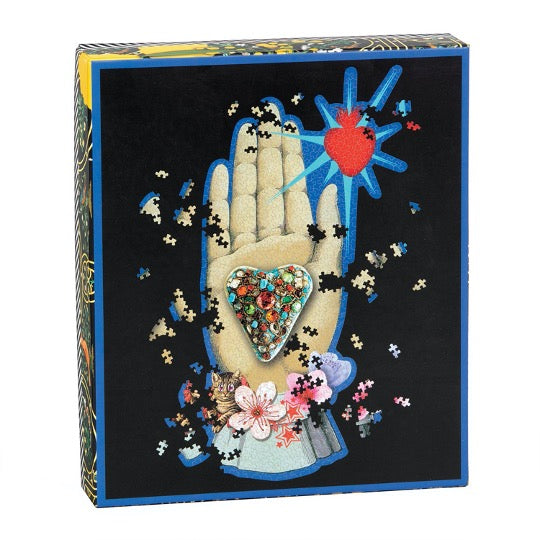 Christian Lacroix puzzle, whimsical illustrated art depicting a hand palm, heart, floral, and heart. 