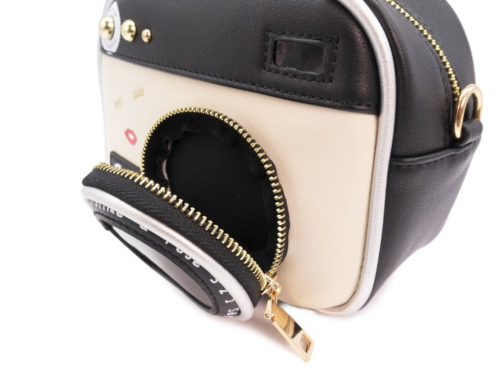 Vintage camera handbag with gold finish chain strap. Lens zipper open.