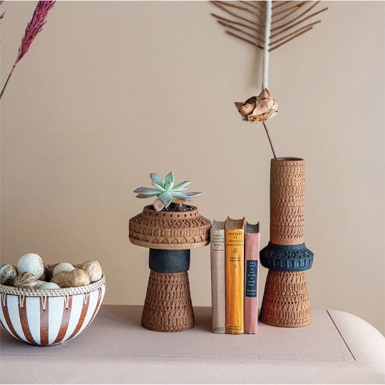 terracotta striped bowl with rattan rim and abstact vases with books and dried succulents 