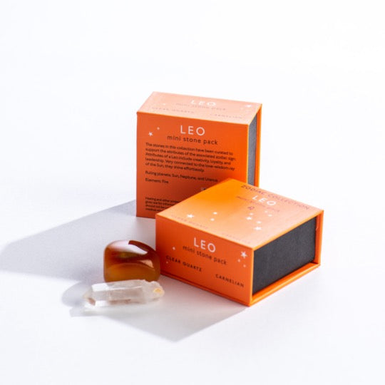 Leo mini stone pack text on orange boxes with Leo constellation pattern. Clear quartz and polished carnelian stones in front. 