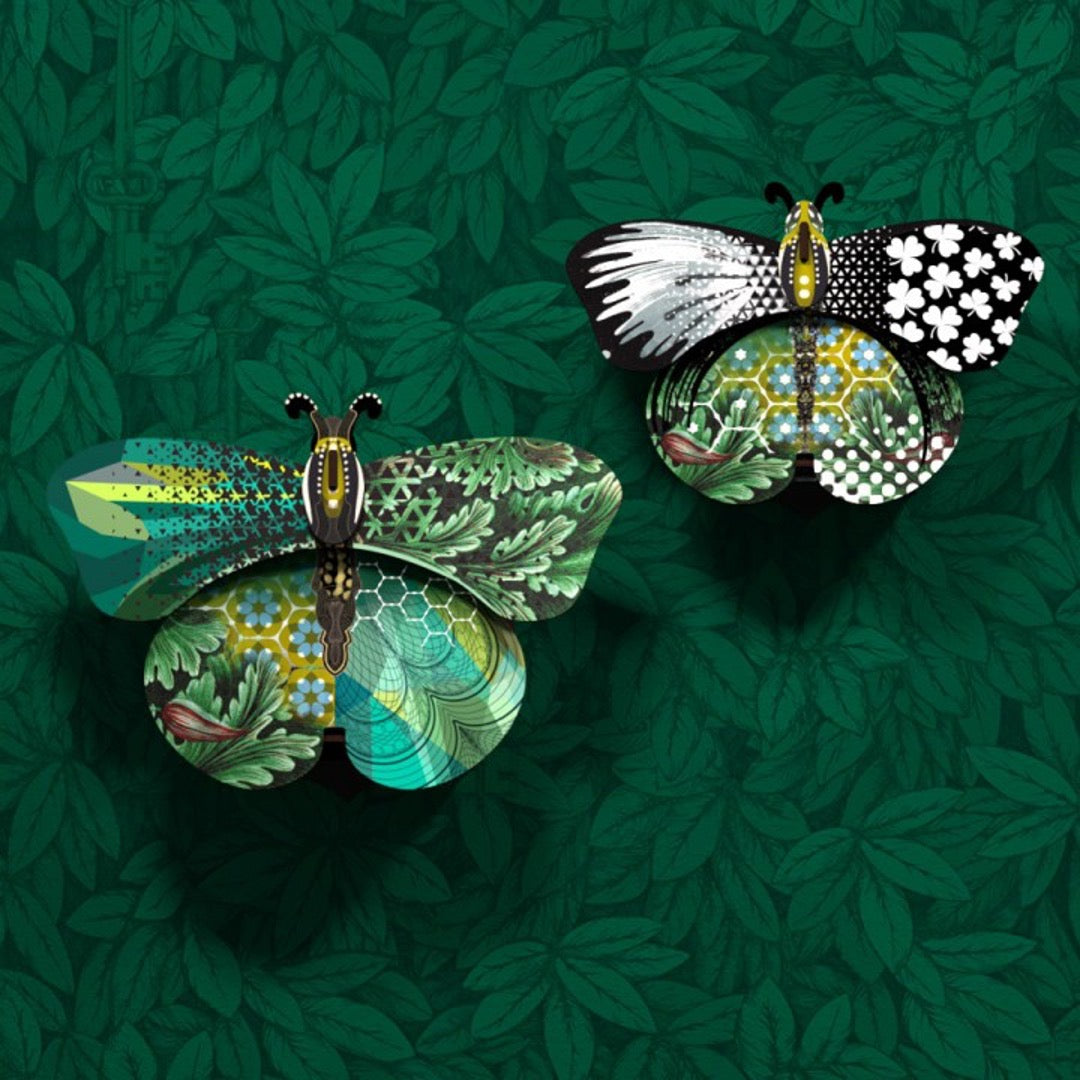 Magda and Aida butterfly wall cabinets with a collage of green, blue, and black patterns on green leaf wallpaper