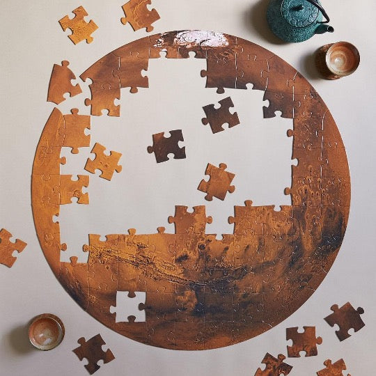 unassembled puzzle of Mars with 2 tea cups and teapot.
