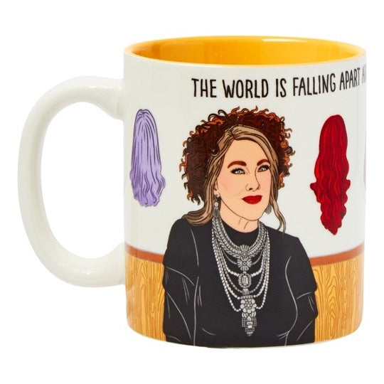 Moira Rose illustration mug with wigs on background. Text across the top that reads, The World Is Falling Apart.  Yellow color inside mug.