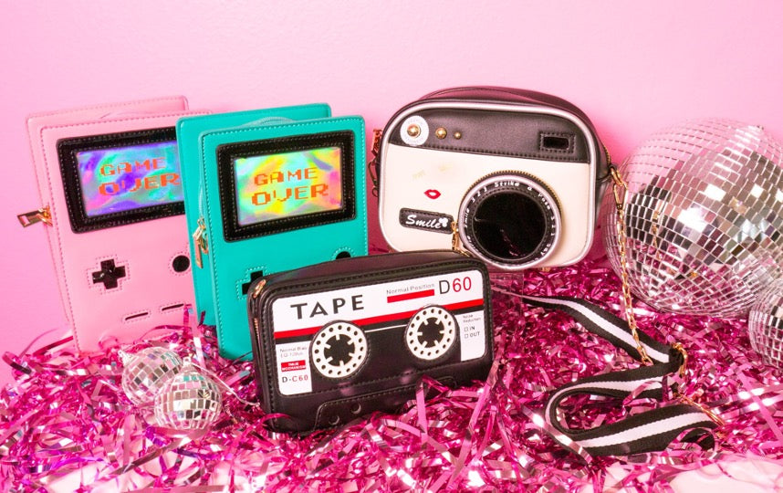 Vintage handbags of camera, tape, green and pink 8-bit gamers.