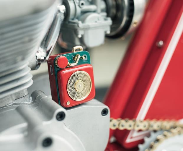 Scarlet red button speaker on motorcycle engine