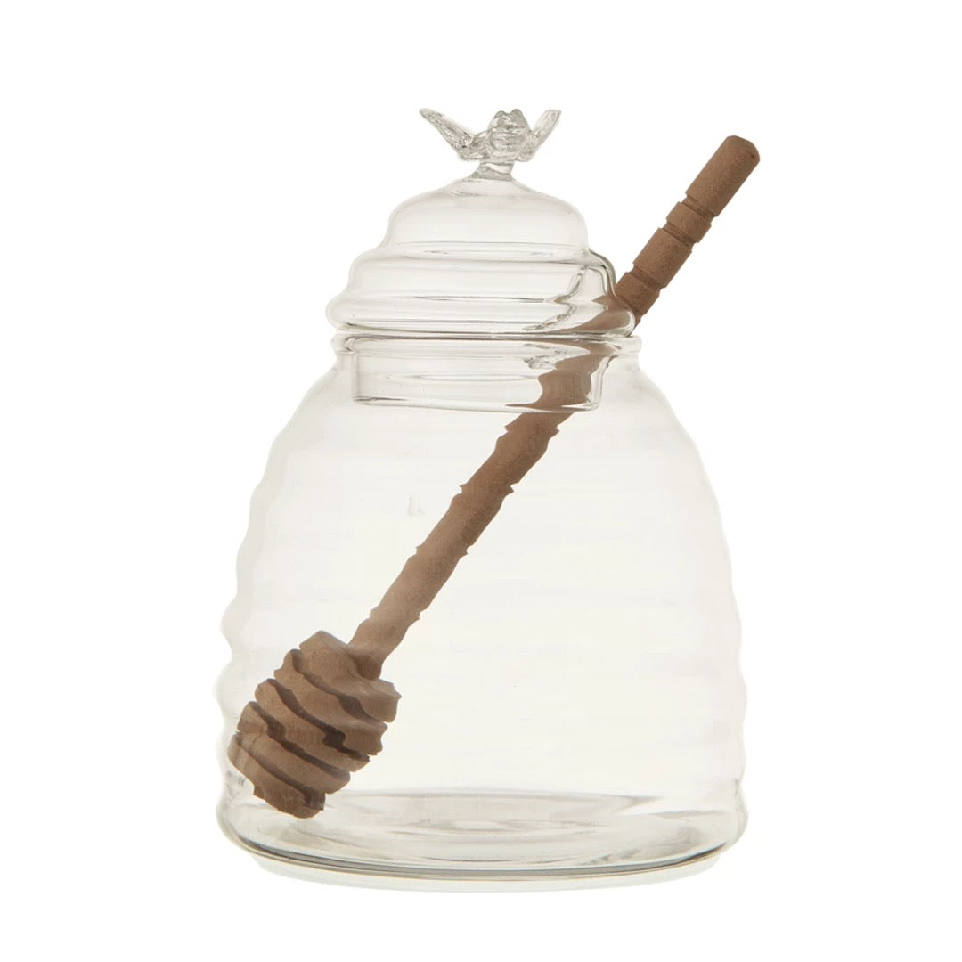 Clear glass honey pot with bamboo dipper.