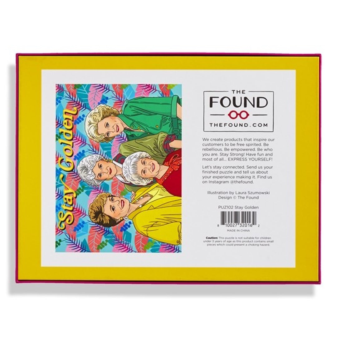 Golden Girls puzzle, multi-color palm leaves in background with Stay Golden text on top. Back of box