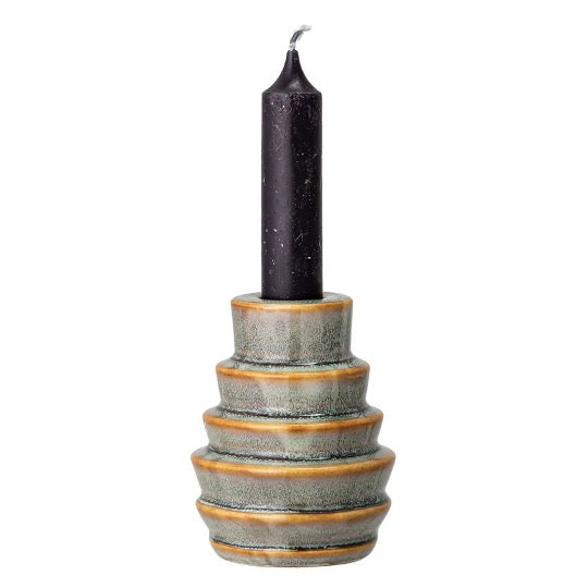 Round stoneware candle holder, blue fades to green and brown colors in the details. Black taper candle inserted on top.