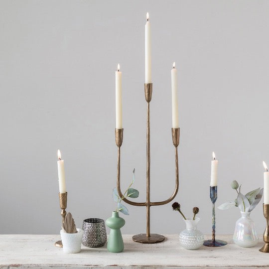 Collection of candelabra and candle holders with vases