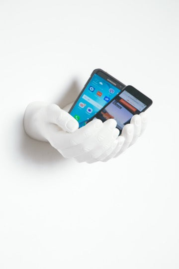 white hands wall mount holding 2 phones